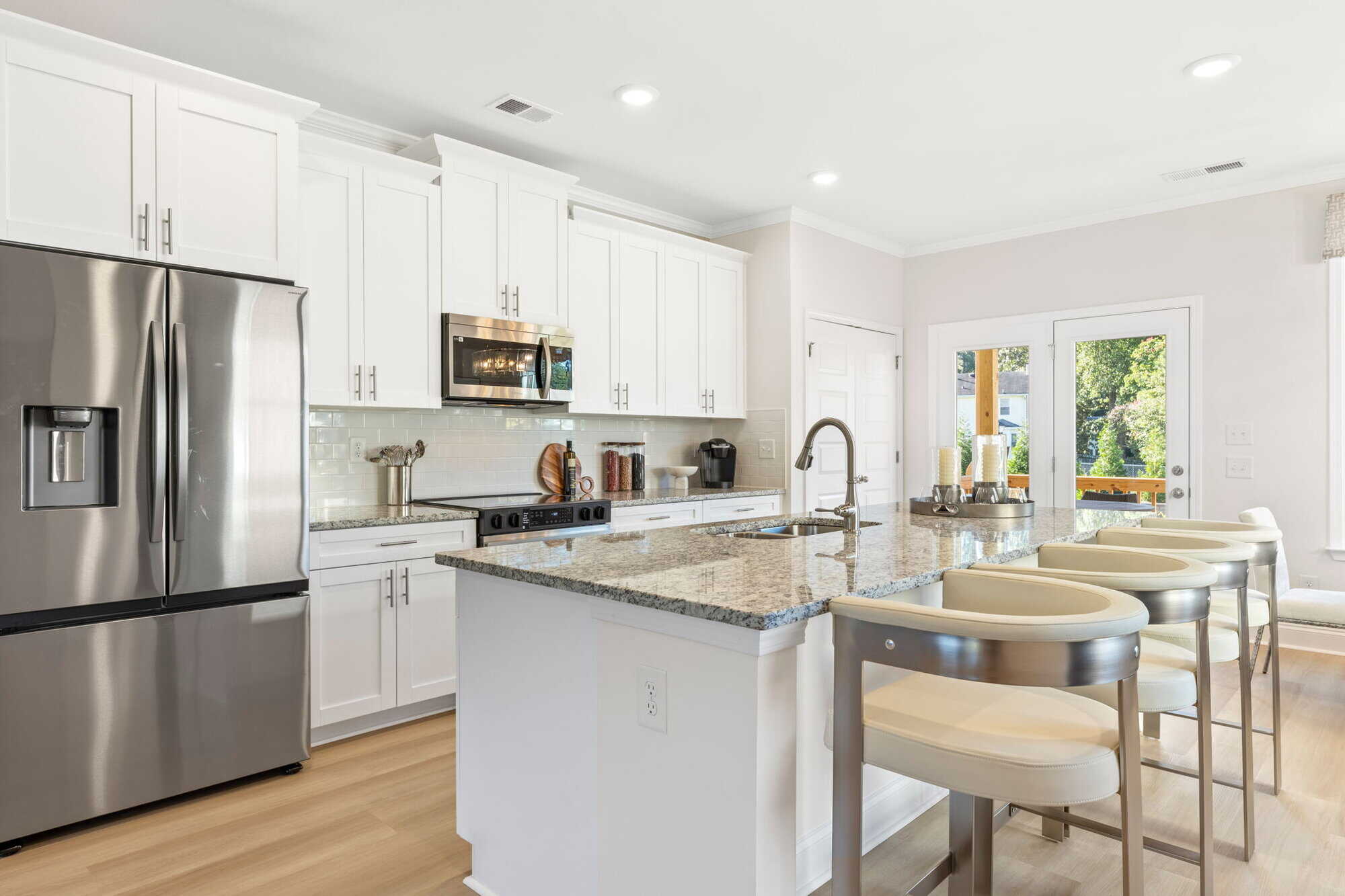 Enclave — kitchen with stainless refrigerator and quartz counters